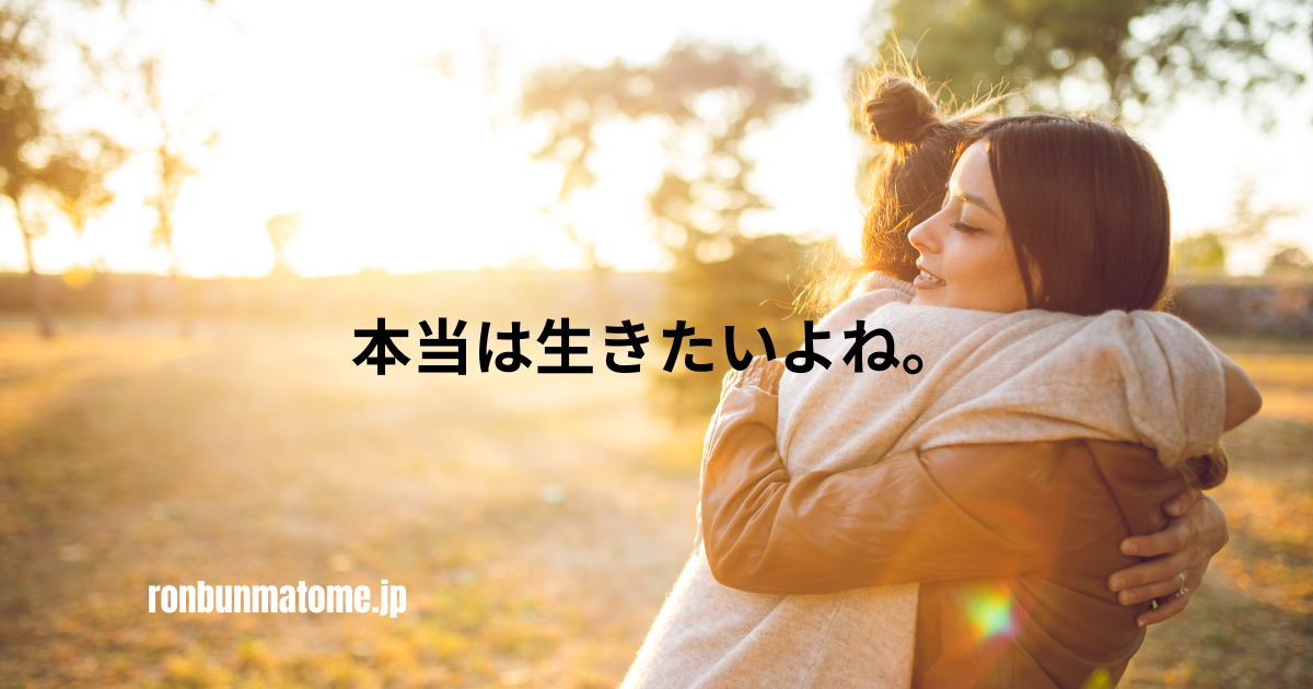 夕暮れの公園で女性二人が抱きしめ合い、「本当は生きたいよね。」という言葉が中央に表示された感情的なイメージ。